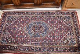 A traditional fireside rug, 163 x 91cm