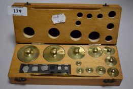 A modern chemists weight set, graduating brass weights housed in a wooden case (incomplete three