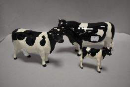 A Beswick Pottery Friesian cattle family, comprising Bull, Cow and Calf (chip to cow and calfs ear)