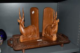 A carved Eastern hardwood tray, with integral handles, carved roundals and foliate border, sold
