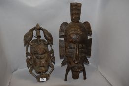 Two early 20th century African tribal wood carved masks in traditional designs, one possibly Fang