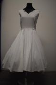 A vintage hand made textured white cotton dress having full skirt and scalloped neckline.