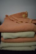 Four vintage cellular blankets, two cream and two pink.