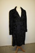A 1930s black coat having frog fastenings and turn up's to cuffs.