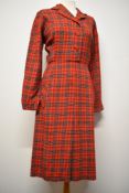 A late 1940s/ 1950s red tartan day dress, having buttons to front and side metal zip, faux pockets