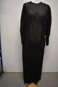 A 1930s semi sheer evening dress, having long sleeves and floral pattern, buttons to nape of neck,