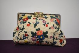 An Art Deco cotton bag of larger size with extensive floral embroidery, floral painted metal clasp