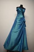 A iridescent turquoise prom dress having full skirt and lace up back, with gathered bodice and