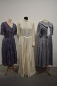Three vintage Laura Ashley dresses, including blue floral with sailor collar.
