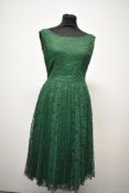 A 1950s green lace dress, fully lined in taffeta with scoop neckline and zip to rear.