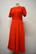 A late 1930s early 1940s red cotton dress with side metal zip, having blue embroidery to skirt,