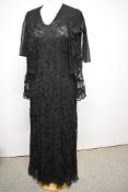 A 1930s black lace bias cut evening gown and matching cape, having crepe inserts to bodice and