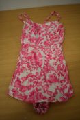 A 1950s pink cotton swim suit having shirred back and floral design, Skylar, made in England label.