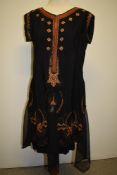 A 1930s black dress having handkerchief hem with bronze and copper soutache braided design