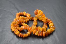 A butterscotch amber bead necklace, comprising numerous graduating asymmetrical beads, 34cm, 47.