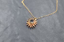A 9ct gold and smoky quartz pendant, the oval-cut stone within multiple radials, marked 375 to