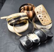A group of eleven horn bracelets, and one expanding wooden bracelet, each of differing size and