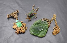 A Chinese carved jadeite pendant, carved in low relief with dragons head, with plated suspension and