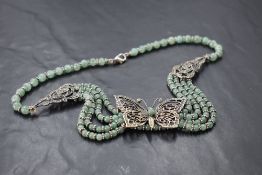An eastern 925 grade white metal and green stone butterfly design necklace, marked 925 to clasp,