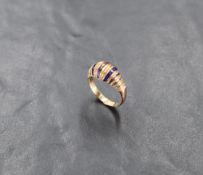 A yellow metal and enamel ring, having bands of ribbed and enamelled decoration, unmarked, N-O, 3.