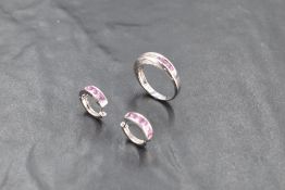 An 18ct white gold band ring having channel set graduated princess cut diamonds and pink