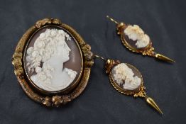A conch shell cameo swivel brooch depicting a bacchanalian maiden in profile with locket en verso