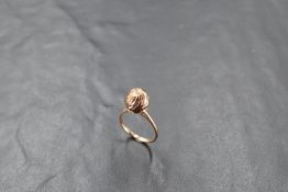 A yellow metal dress ring, of spirally faceted globular form over a plain unmarked shank, ring