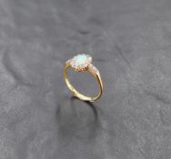 An opal and diamond chip cluster ring with diamond chip set angular shoulders on an 18ct gold