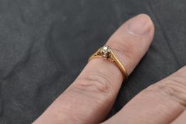 An 18ct gold and diamond solitaire ring, the small illusion-set diamond within pierced tapering