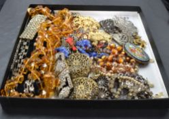A selection of vintage jewellery including buckles, mosaic brooch, amber glass beads, etc