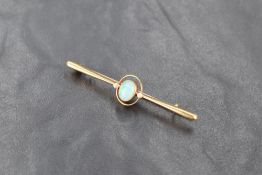 A 15ct gold opal and seed pearl bar brooch, the central oval opal cabochon enclosed within a seed