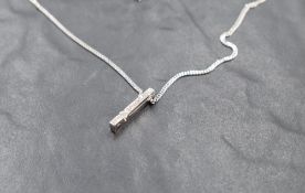 An Italian 18ct white gold diamond pendant with chain having a tension set diamond amongst 10
