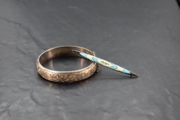 An early 20th Century silver and enamel lozenge shaped bar brooch and a later silver hinged bangle