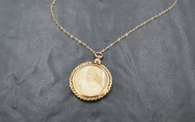 A vintage glass locket of circular form in a 9ct gold decorative mount on a 9ct gold chain, approx
