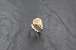 A gent's 9ct gold signet ring with inset diamond in star mount to barke effect shoulders, size Q &