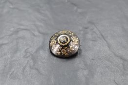 A tortoise shell brooch of circular form having extensive floral picque work decoration