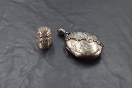 A Victorian white metal locket having engraved Owl & Crane decoration and a Charles Horner silver