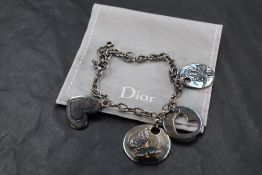 A Christain Dior silver charm bracelet having four circular disc charms, with originl bag and box