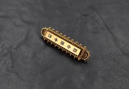 A yellow metal bar brooch having five inset old cut diamonds, total approx 0.25ct in a decorative