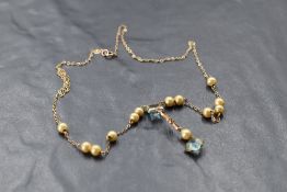 A yellow metal necklace bearing plaque stamped 9ct having blue paste and simulated pearl decoration,