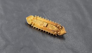 A yellow metal bar brooch having ball and wire work decoration with glass locket en verso, unmarked,