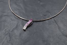 An 18ct white gold pendant having 26 princess cut diamonds and pink sapphires in a channel set