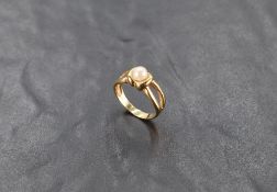 A yellow metal ring stamped 585 having a central cultured pearl to open shoulders< size N & approx