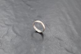 An 18ct white gold wedding band with textured surface, marked 18, ring size Q-R, 4.5grams.
