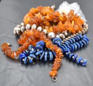 Two amber bead necklaces 141grams gross, a Lapis Lazuli bead necklace, a white metal bead necklace