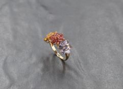 A multi coloured (fancy) sapphire triple daisy cluster ring in shades of yellow, red and pale blue