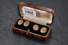 A pair of 9ct gold cufflinks of oval form having engine turned striped decoration and chain