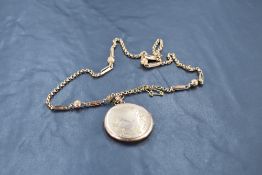 A Victorian rose gold locket of circular form having swallow and floral decoration on a fancy link