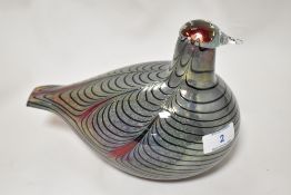 An art glass bird study having mottled iridescent blue banding on red ground.