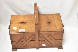 A mid century cantilever sewing box with contents.